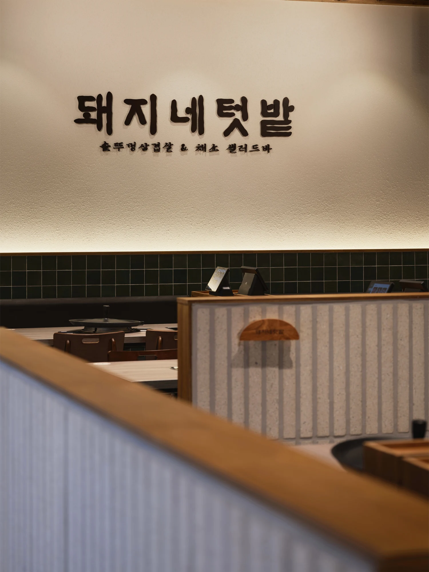 돼지네텃밭 본점 — 밝은 벽면에 배치한 브랜드 사인